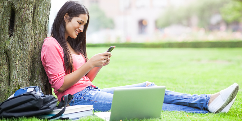 hispanic college student texting on her cellphone