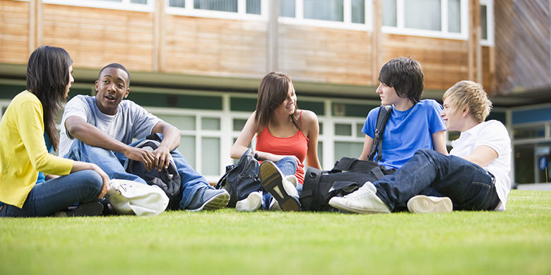 College students sitting and talking on campus lawn