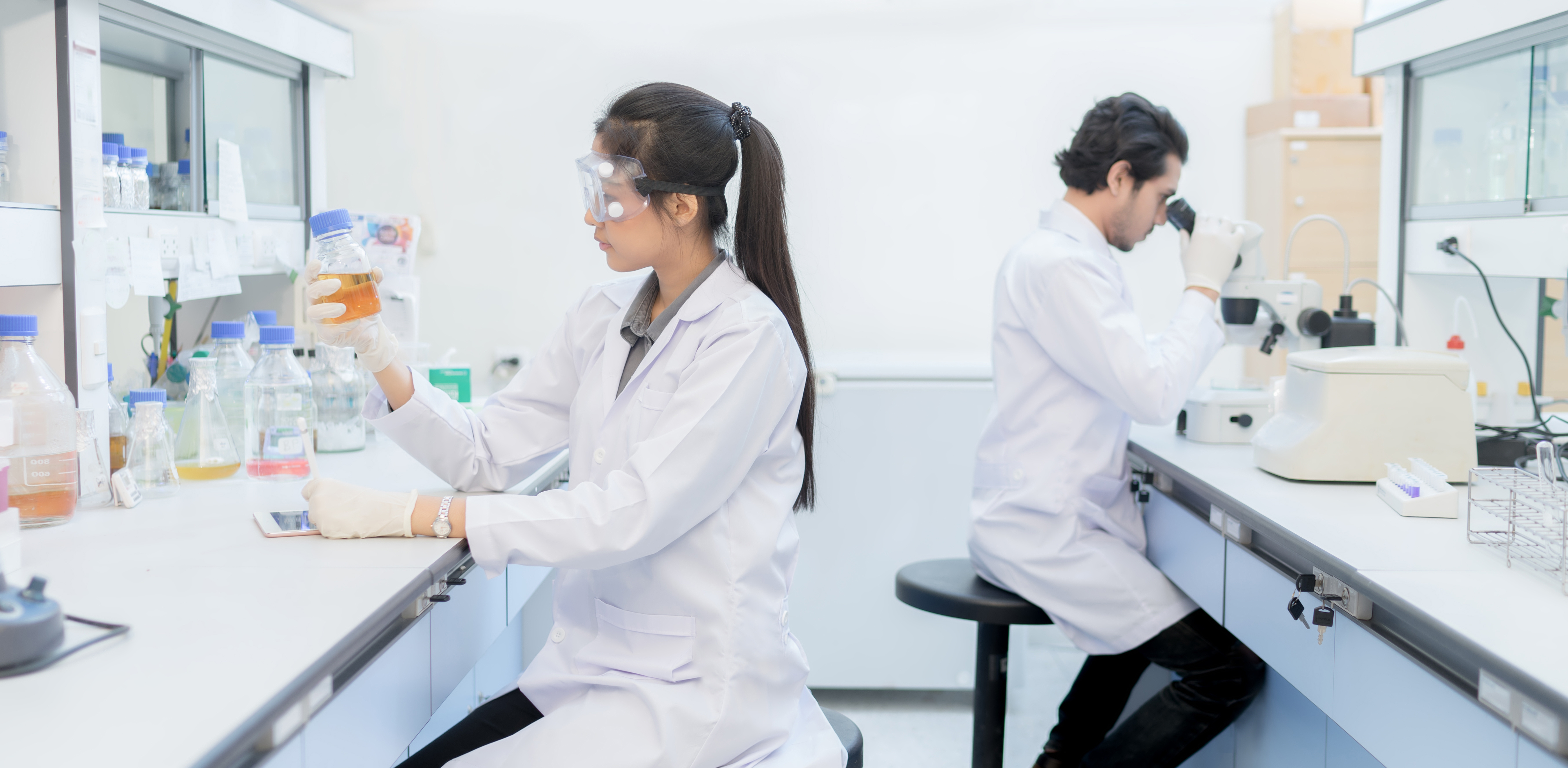 Young woman scientist in the laboratory working at lab with test tube