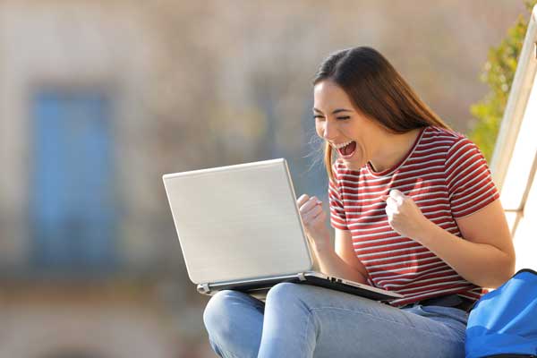 Excited student looking at her computer